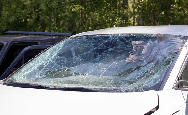 Close-up of a car with a broken windshield after a fatal crash. Consequence of a fatal car accident. Automobile danger. Reckless dangerous driving. Vehicle after an accident with a pedestrian