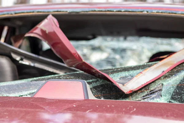 A car after an accident with a broken rear window. Broken window in a vehicle with a rear brake light. Interior wreckage, detailed close-up view of a damaged modern car