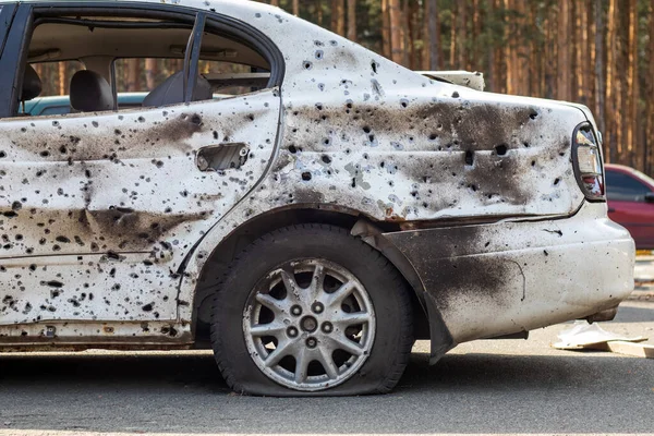 Shot, damaged cars during the war in Ukraine. The vehicle of civilians affected by the hands of the Russian military. Shrapnel and bullet holes in the body of the car. War of Russia against Ukraine