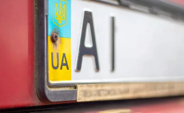 Ukrainian car registration number with national flag and coat of arms. Region code, Kyiv region AI, 10 region. Car number without numbers on the front bumper of the car, close-up
