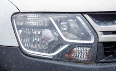 Renault Duster için ön sağ far. Çapraz ya da beyaz renkli siyah tamponlu SUV. Aracın önü görünüyor. Bir arabanın detaylı yakın çekim ışığı var. Dış görev ayrıntıları. Ukrayna, Kyiv - 12 Haziran. 2022