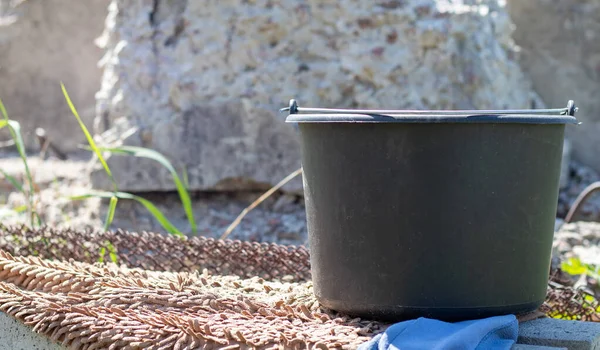 夏天花园里的黑色塑料桶 里面有水 花园里的蓄水池 炎炎夏日 浇灌花园的器皿 — 图库照片