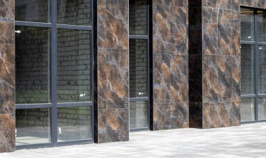 Yeni bir modern yerleşim biriminde sokak seviyesinde panoramik pencereli ticari binalar. Tipik bir binada kiralık ticari gayrimenkul