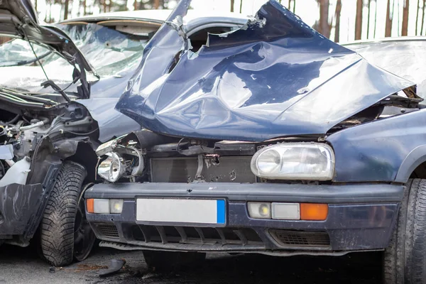 Broken car after a traffic accident in the parking lot of a repair station. Car body damage workshop outdoors. Sale of insurance cars. Accident on the street, car after a collision in the city