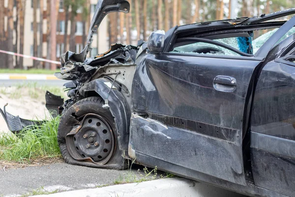 Black car after a terrible accident on the side of the road. Frontal and side impact. Life insurance. An accident without the possibility of recovery. Side view. Damage after an accident