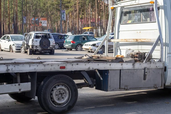 Lots of old cars ready for recycling. Car removal by tow truck. The car is getting ready to be loaded onto a tow truck. Old wrecked cars in a junkyard are waiting to be destroyed in a recycling park