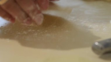 Bir kadın evde turta pişirir. Evde pişirme ve pişirme. Hamuru pişirmek için hazırlıyorum. Test grubu. Bir kadın ev mutfağında hamur mayalı turta hazırlıyor. El yapımı yemek hazırlama konsepti.