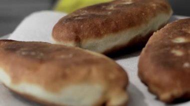 Mutfakta bir kadın dolgulu kızarmış turta hazırlıyor. Ev yapımı iştah açıcı turtalar. Hazır kızarmış turtalar, farklı dolgularla altın çıtır çıtır..