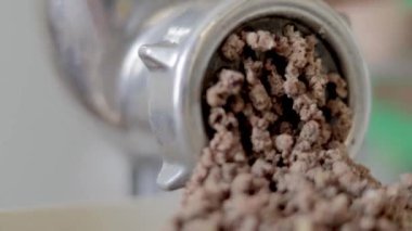 Tebdili kıyafet bir kadın ev mutfağında et pişirir. Manüel mekanik et öğütücüsünde kıyma. Taze haşlanmış et, eski metal öğütücüde öğütülür. Mutfakta yakın plan.