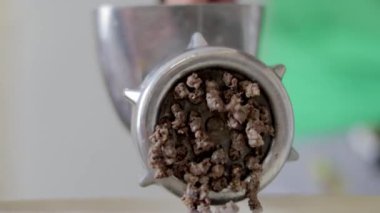 Tebdili kıyafet bir kadın ev mutfağında et pişirir. Manüel mekanik et öğütücüsünde kıyma. Taze haşlanmış et, eski metal öğütücüde öğütülür. Mutfakta yakın plan.