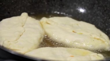 Kadın şef kaynamış yağda turta hazırlar. Doldurulmuş kızarmış turta. Garson patates kızartması ya da et ve sebze ile doldurulmuş belyashi 'yi yağda kızartma tavasına koyar. Ev yapımı, yemek pişirme.