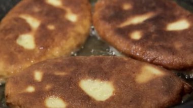 Kadın şef kaynamış yağda turta hazırlar. Doldurulmuş kızarmış turta. Garson patates kızartması ya da et ve sebze ile doldurulmuş belyashi 'yi yağda kızartma tavasına koyar. Ev yapımı, yemek pişirme.