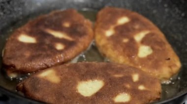 Kadın şef kaynamış yağda turta hazırlar. Doldurulmuş kızarmış turta. Garson patates kızartması ya da et ve sebze ile doldurulmuş belyashi 'yi yağda kızartma tavasına koyar. Ev yapımı, yemek pişirme.