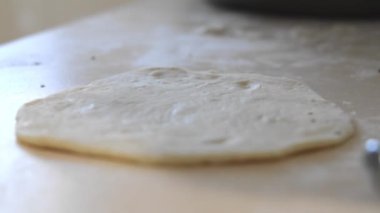 Kadınların elleri bir hamur parçasına et doldurur. Doldurulmuş ev yapımı turta. Şef haşlanmış etli bir kızarmış turta için hamur yapar. Ev hanımı hamuru et ve sebzelerle doldurur.