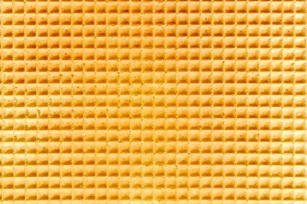 Waffle relief texture background. Sweet tasty dessert. Empty golden waffle texture, background for your design with copy space. Close-up pattern of a traditional Dutch waffle as a background