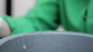Beyaz eldivenli bir kadının elleri taze patatesleri soyar, yakın plan. Organik patates temizliyorum. Kadın elinin mutfak bıçağıyla taze patates soyması, yemek hazırlama konsepti..