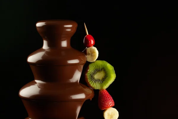 Fruits in chocolate fountain — Stock Photo, Image