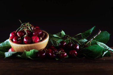 Tahta masadaki bir kasede taze kirazlar. 