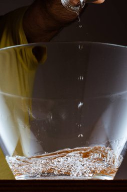 Birisi bardağa sıvı döküyor.