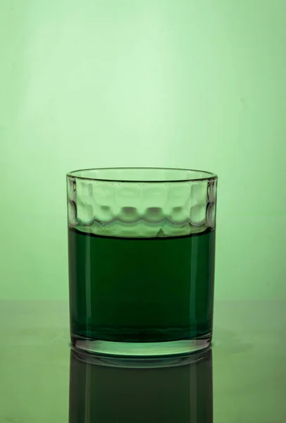 绿色背景的杯子水 — 图库照片