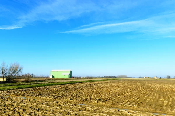 Groene gebouw onder geploegd velden, valeggio, lomellina (Italië) — Stockfoto