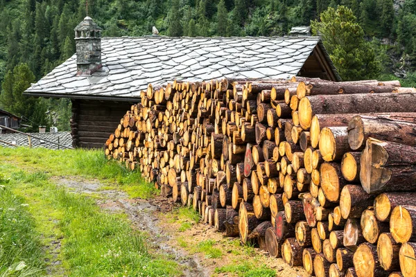 Pila di legno e casa in legno con tetto in pietra, Cuneaz (Italia) ) — Foto Stock