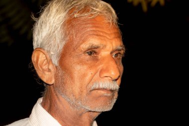 Güzel, şirin, yaşlı Hintli Hindu, yakışıklı çiftçinin, siyah ve sade yaratıcı geçmişi olan yüz resmi.