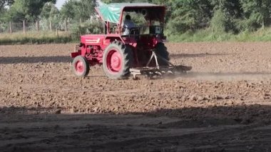 Pali Rajasthan, Hindistan. 29 Ekim 2021. Hintli bir çiftçi traktör ve saban yardımıyla tarlayı sürüyor.