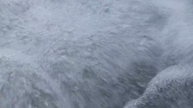 Yukarıdan düşen su akışından yükselen su kabarcıklarının yakın çekim görüntüleri