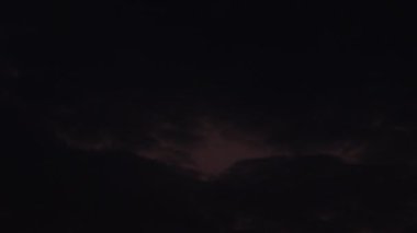 Close up footage of Scene of sun rising from behind black clouds in the morning