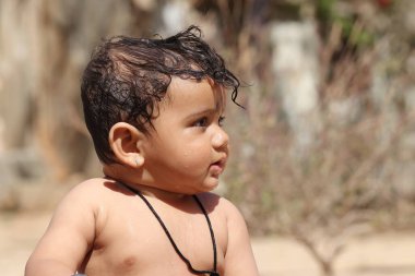 Hindistan 'da gülümseyen yüzlü, güzel, mutlu bir erkek bebeğin yakından çekilmiş fotoğrafı.