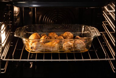 Tavuk budu cam tepside fırında pişiyor.