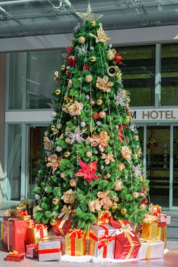 Renkli süsler ve hediye kutularıyla süslenmiş Noel ağacı..