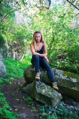 kayanın üzerinde oturan genç kız