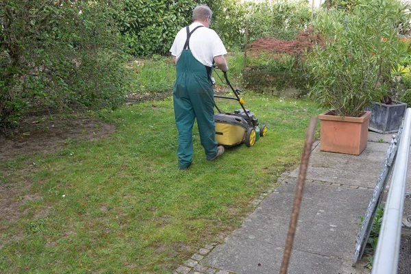 Man Pushing Lawnmower Small Backyard Spring Rear View Man Overall — 图库照片