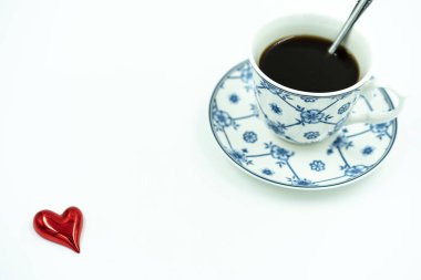 Beyaz arka planda siyah kahve ve kırmızı kalpli beyaz mavi porselen kahve fincanı..