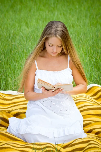 Молодая красивая девушка с книгой в природе — стоковое фото