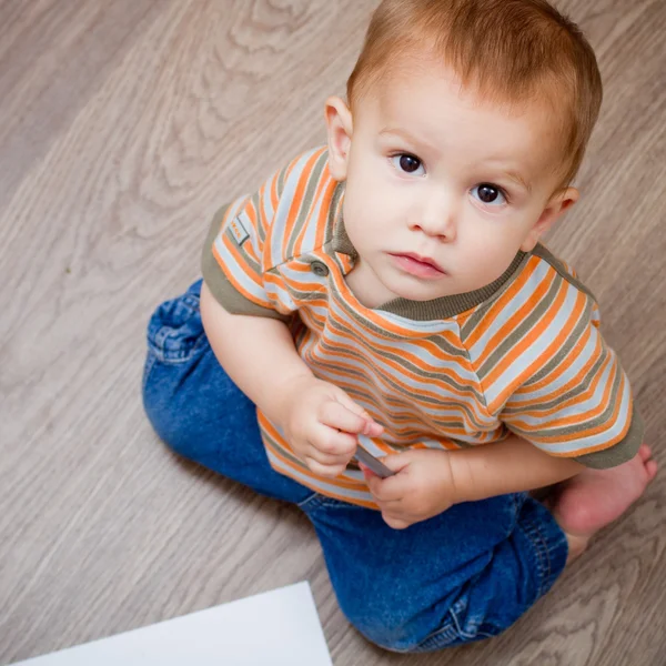 Baby sitting on the floor and looking up — Stock Photo, Image