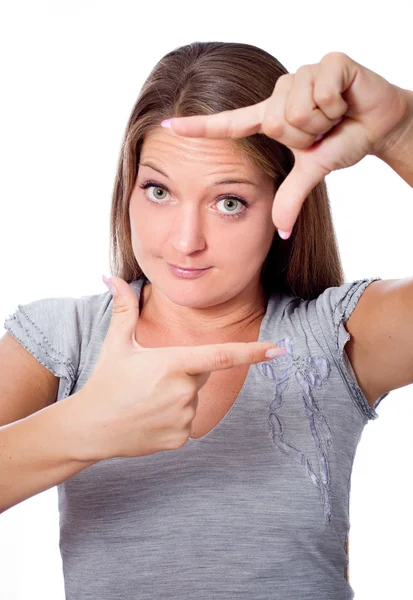 Ragazza sbirciando attraverso la sua cornice mano — Foto Stock