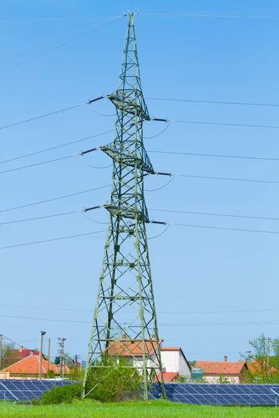 Solarmodul gegen Hochspannungsmast — Stockfoto