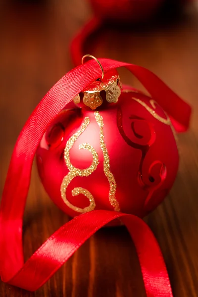 Bugiganga de Natal vermelho com fita vermelha no chão — Fotografia de Stock