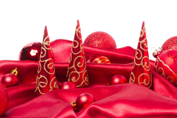 Rode kerstballen en xmas bomen op rode doek — Stockfoto