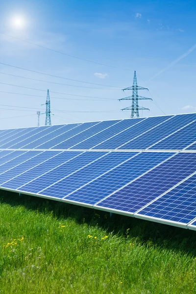 Solar panel against high voltage tower — Stock Photo, Image