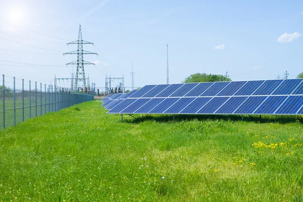 Solpanel mot högspänning tower — Stockfoto