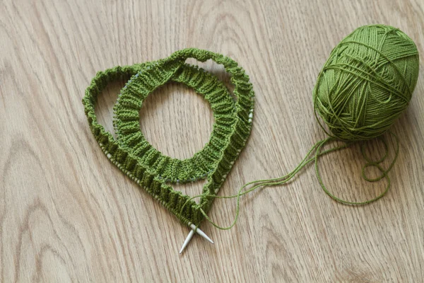 心形状织针和绿色的羊毛纱--顶视图 — 图库照片