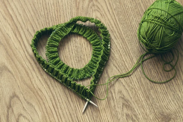 ハート形の編む針とグリーン ウール糸 - トップ ビュー — ストック写真