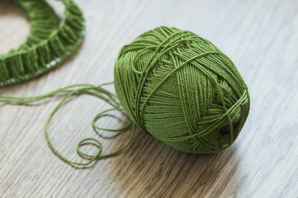 Agulhas de tricô em forma de coração e fios de lã verde - vista superior — Fotografia de Stock