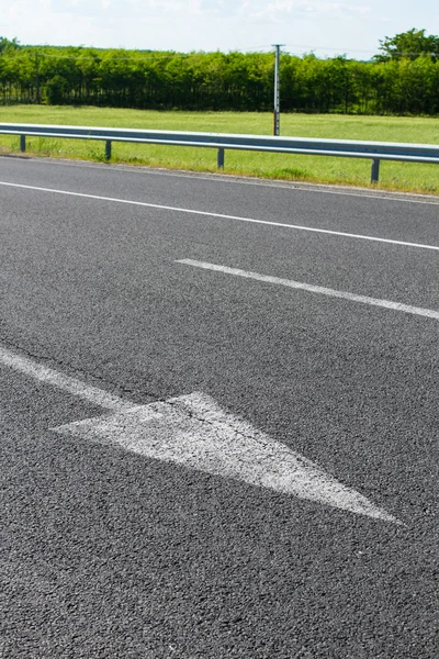 Flechas sobre asfalto que muestran el tráfico a dónde ir — Foto de Stock