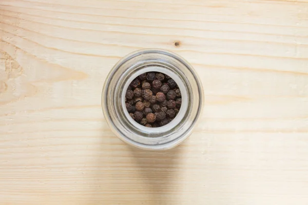 Black pepper (Piper nigrum) on the wooden table — Stock Photo, Image