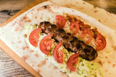 Köfteli Shawarma, soslu, domatesli, biberli, peynirli, otlu, lahanalı, soğanlı ve sarımsaklı.